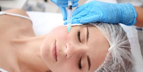 A beautician performs a facial rejuvenation treatment using plasma